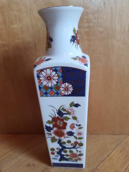 Eine kleine Vase mit asiatischen Blumen und Dekor