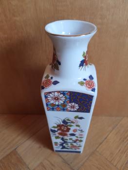 Eine kleine Vase mit asiatischen Blumen und Dekor